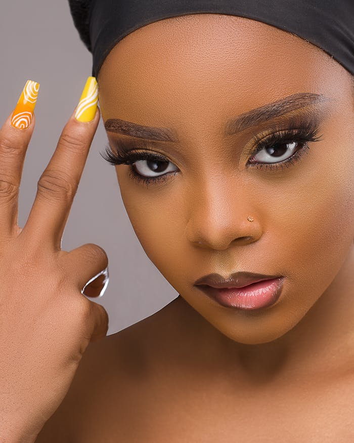 Close-up portrait of a black woman with fierce expression and stylish nail art.