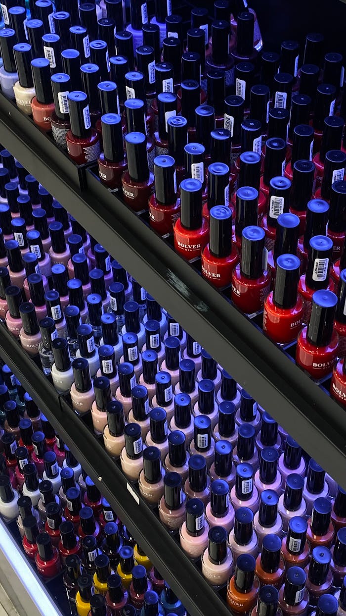 Colorful assortment of nail polish bottles displayed neatly on store shelves, offering a variety of choices.